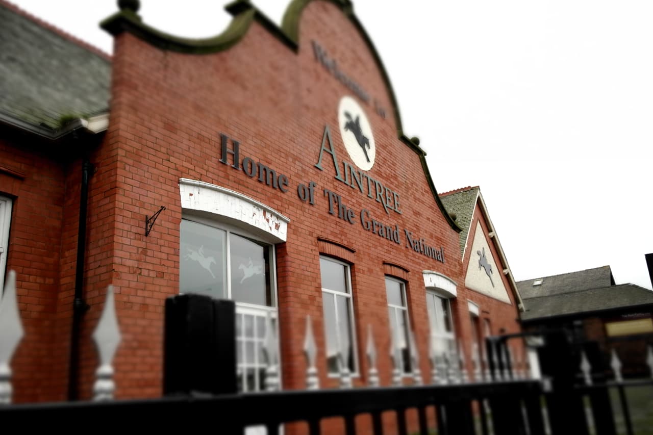 The red brick entrance building at Aintree carrying the course name and the words Home of The Grand National.