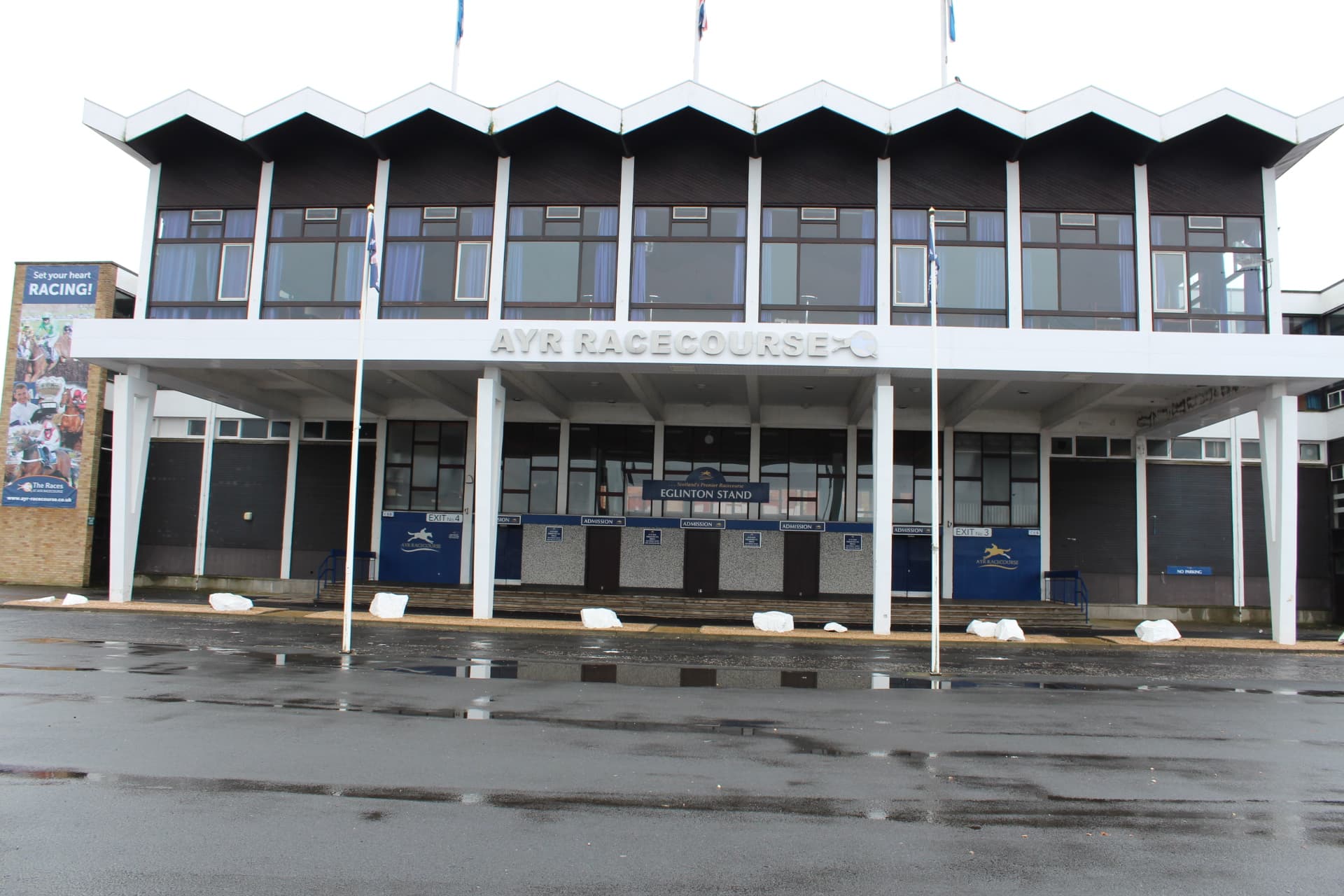 The Eglinton Stand at Ayr, its turnstiles shuttered and the course name across the front.