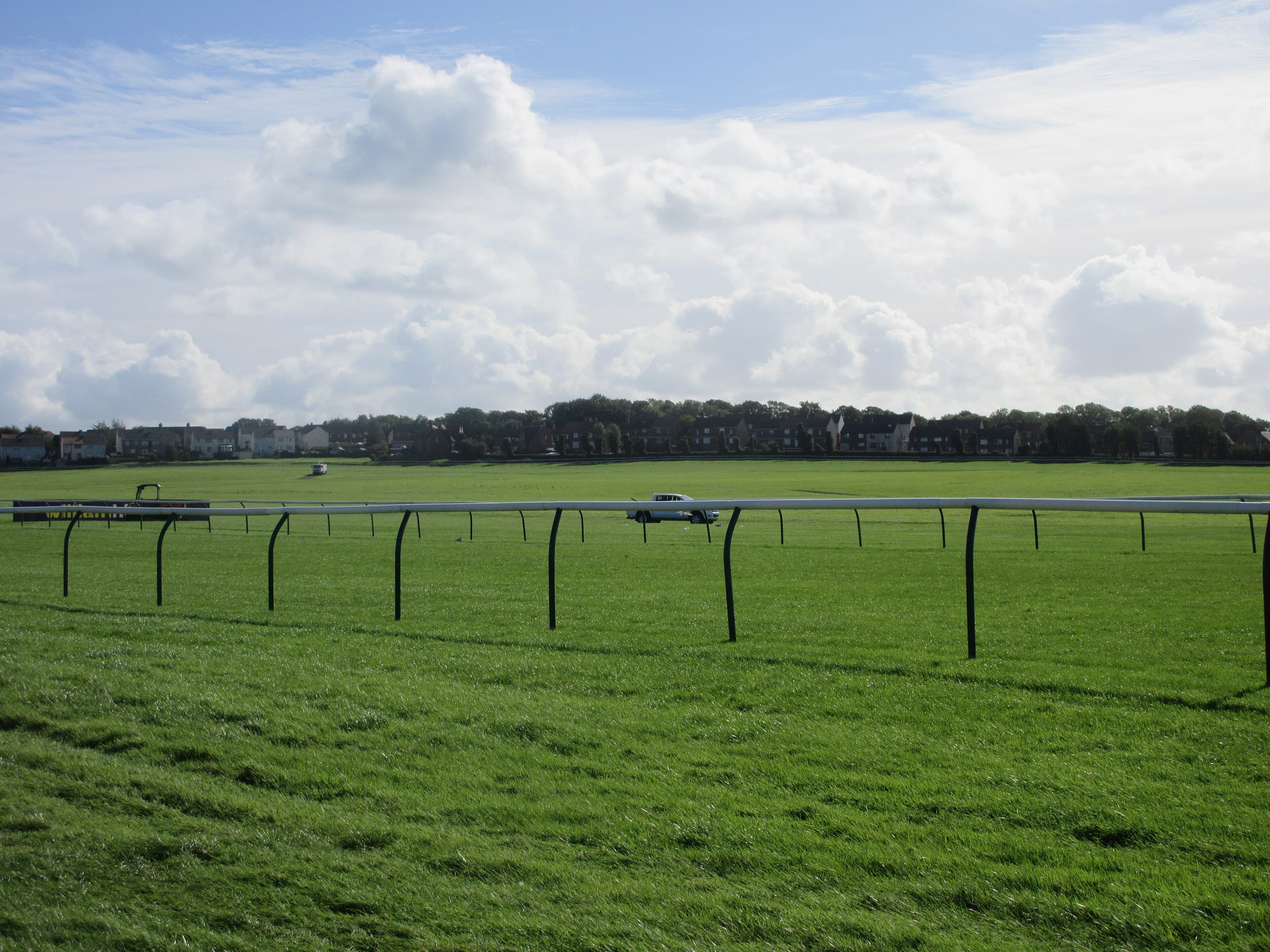 The running rail at Ayr with cloud piled over the far side of the course.