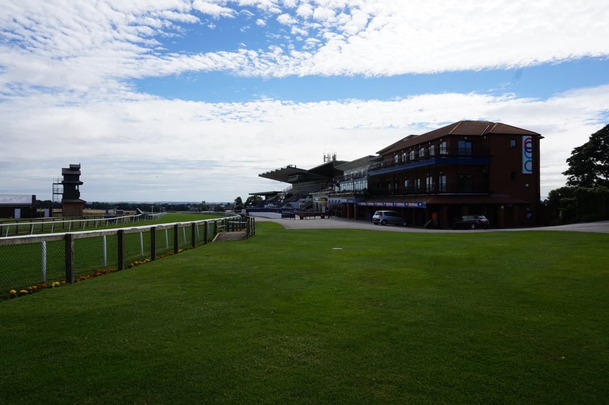 The Beverley grandstand seen along the rail under a mackerel sky.