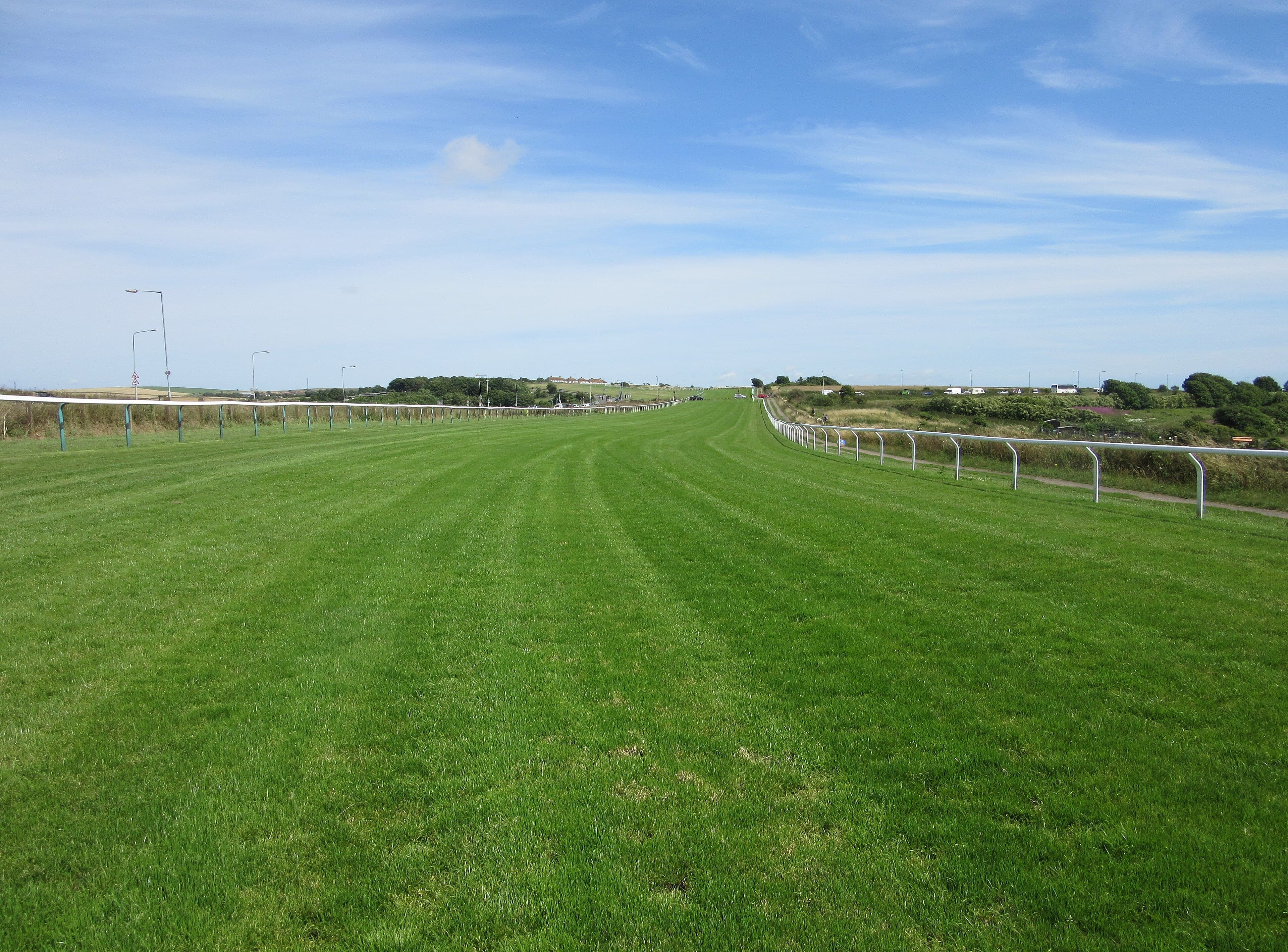 The Brighton straight running down over the top of Whitehawk Hill under a clear sky.