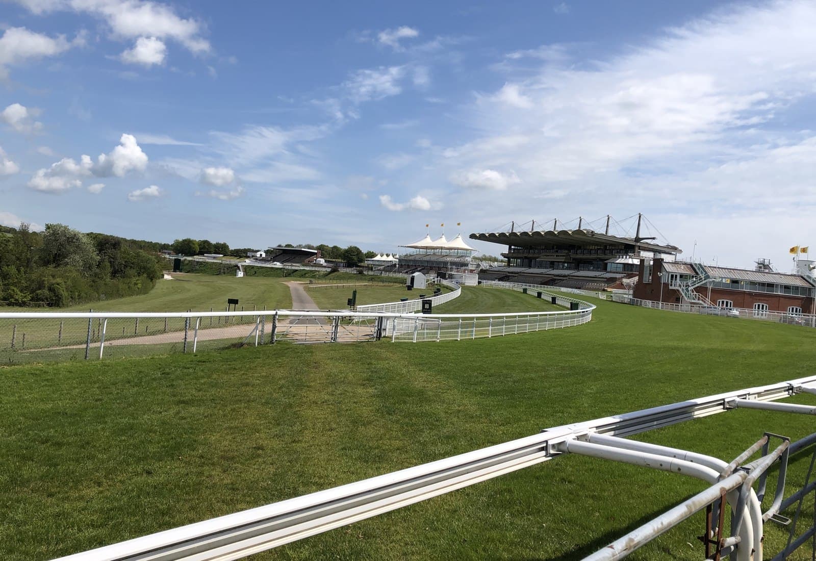 The Goodwood stands beyond the bend, the rail sweeping round in front of them on a bright day.