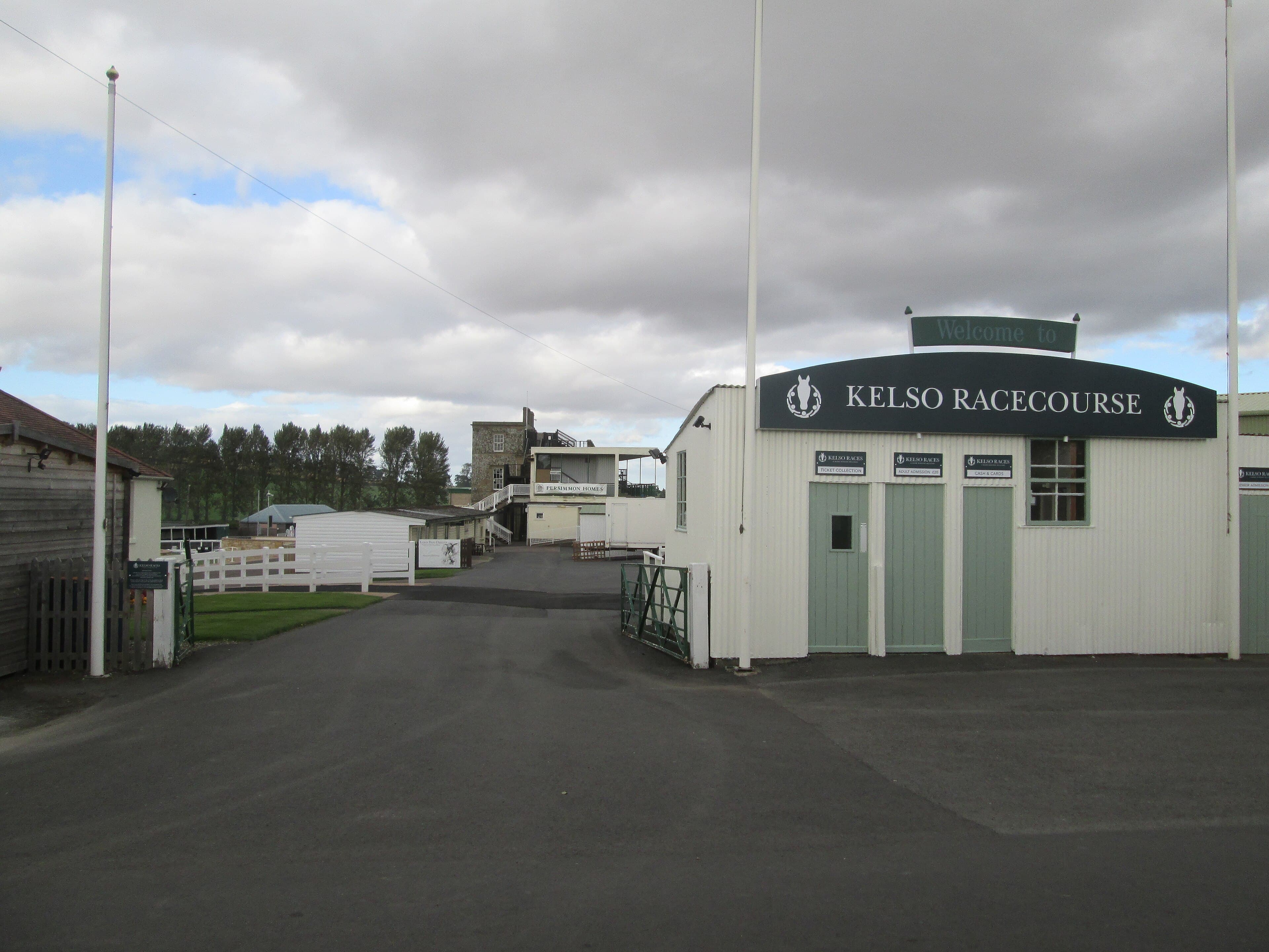 The white timber entrance building at Kelso racecourse under a sign reading Welcome to Kelso Racecourse.