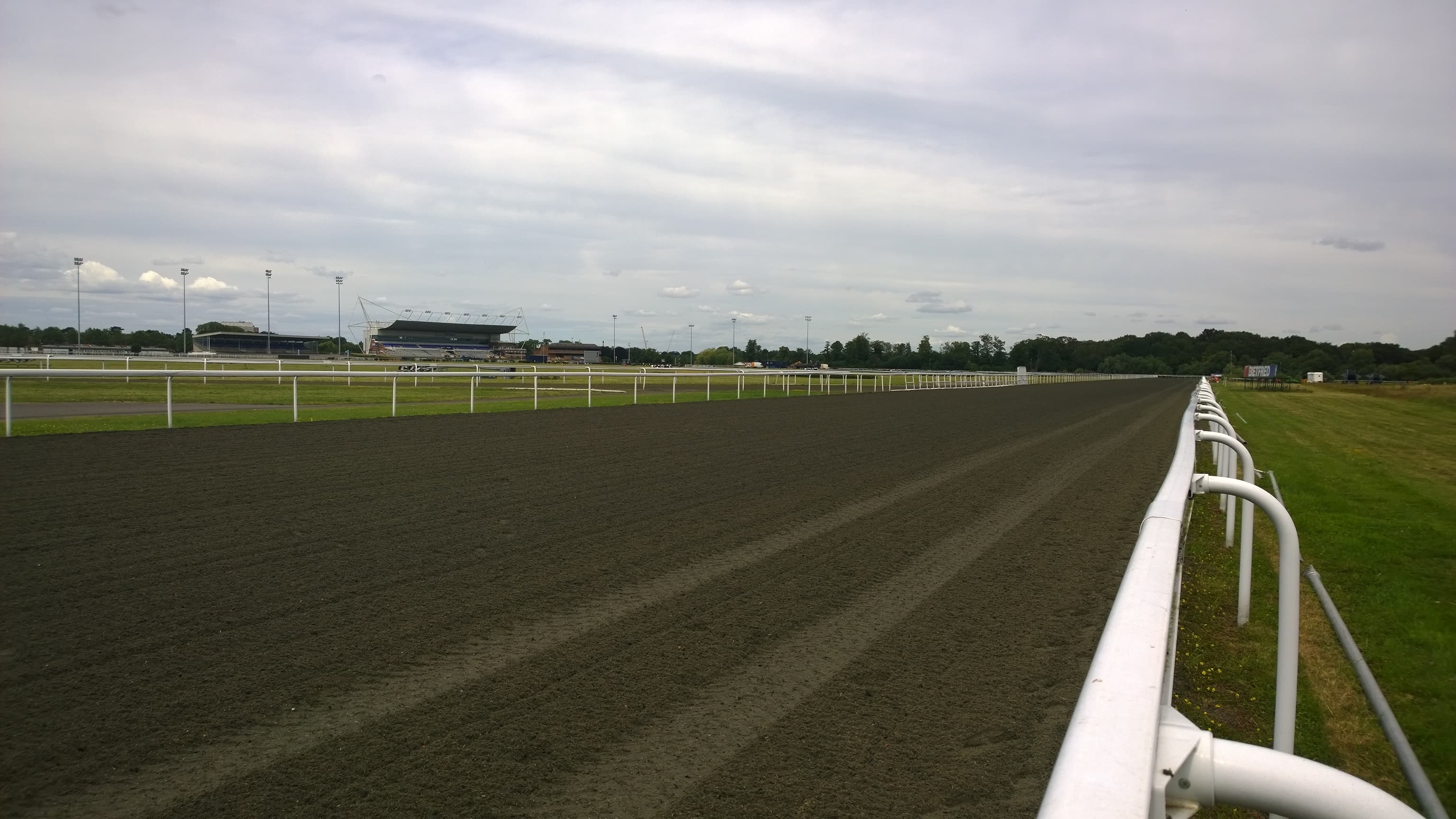 Looking along the Kempton Park Polytrack towards the grandstand, the turf course beyond the far rail.