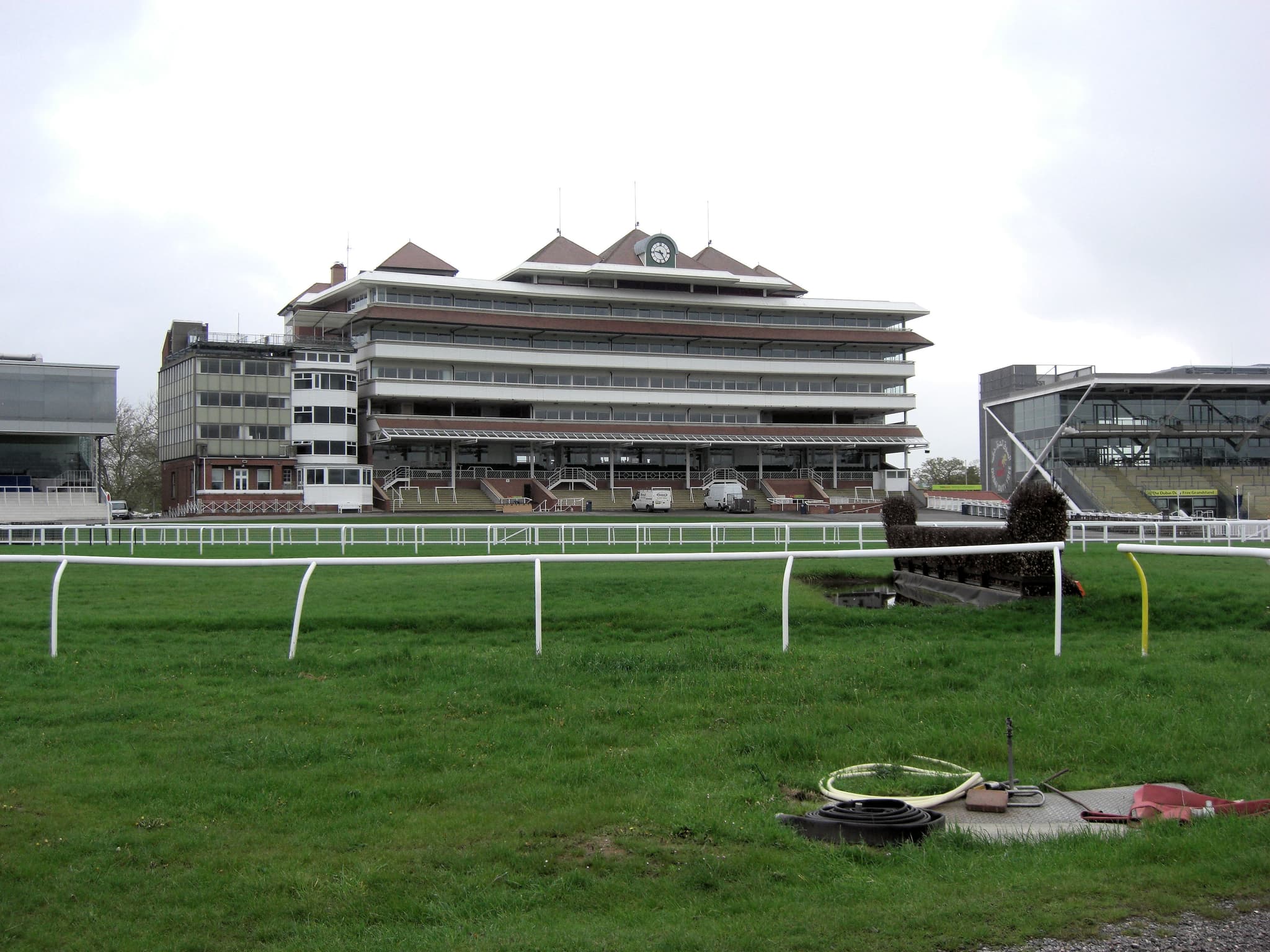 The main stand at Newbury seen across the track, with the water jump and running rails in front.
