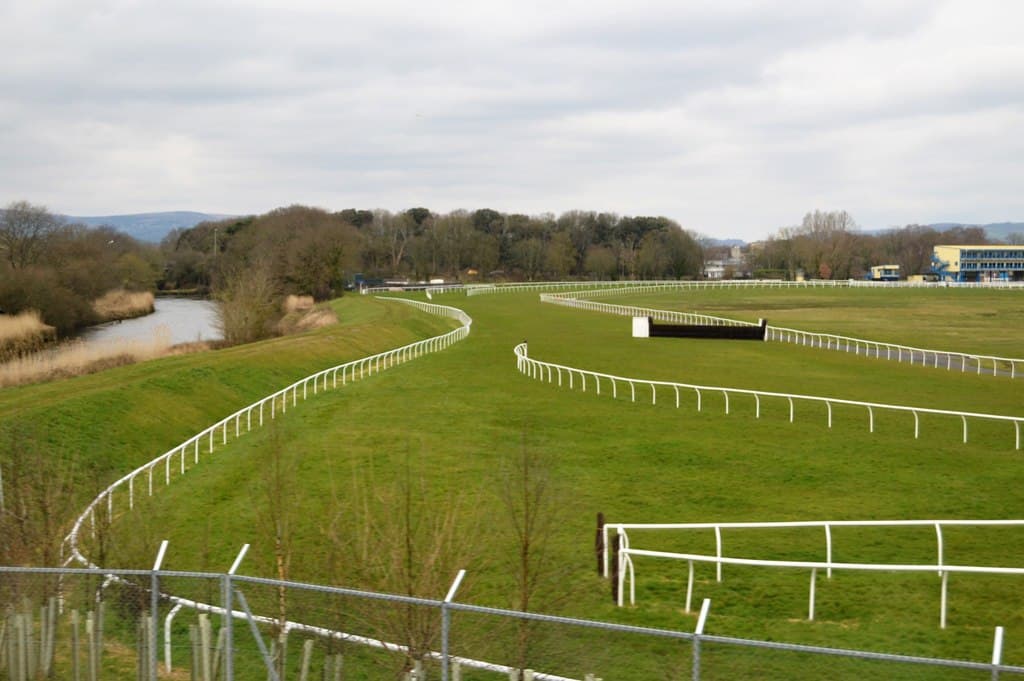 Newton Abbot racecourse from the riverside, the rail sweeping round the bend with the stands in the distance.