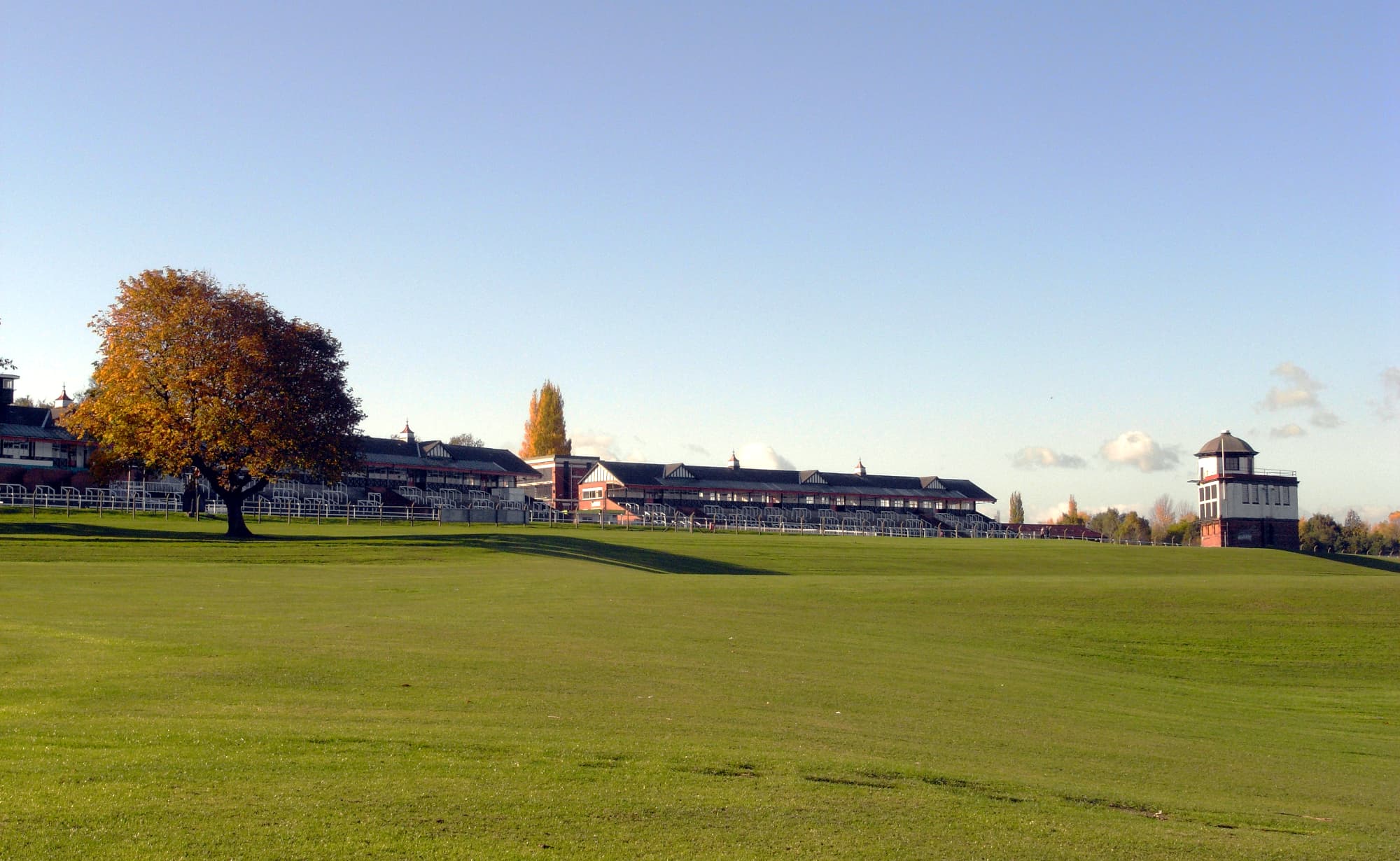 Pontefract Racecourse on an autumn evening, the turf sweeping up to the long stands and the clock tower.