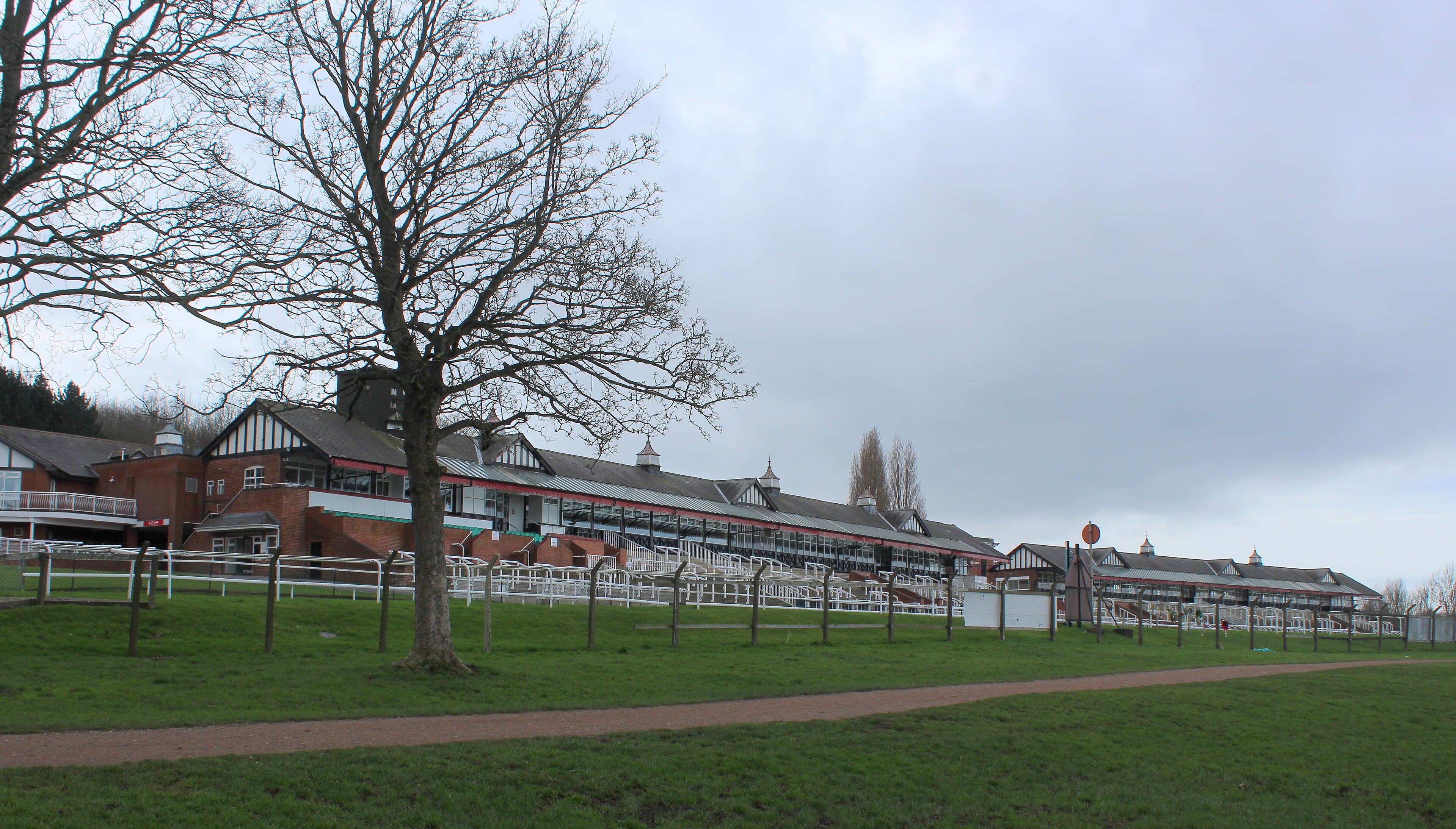 The long line of stands at Pontefract seen along the rail from the park side on a still winter day.