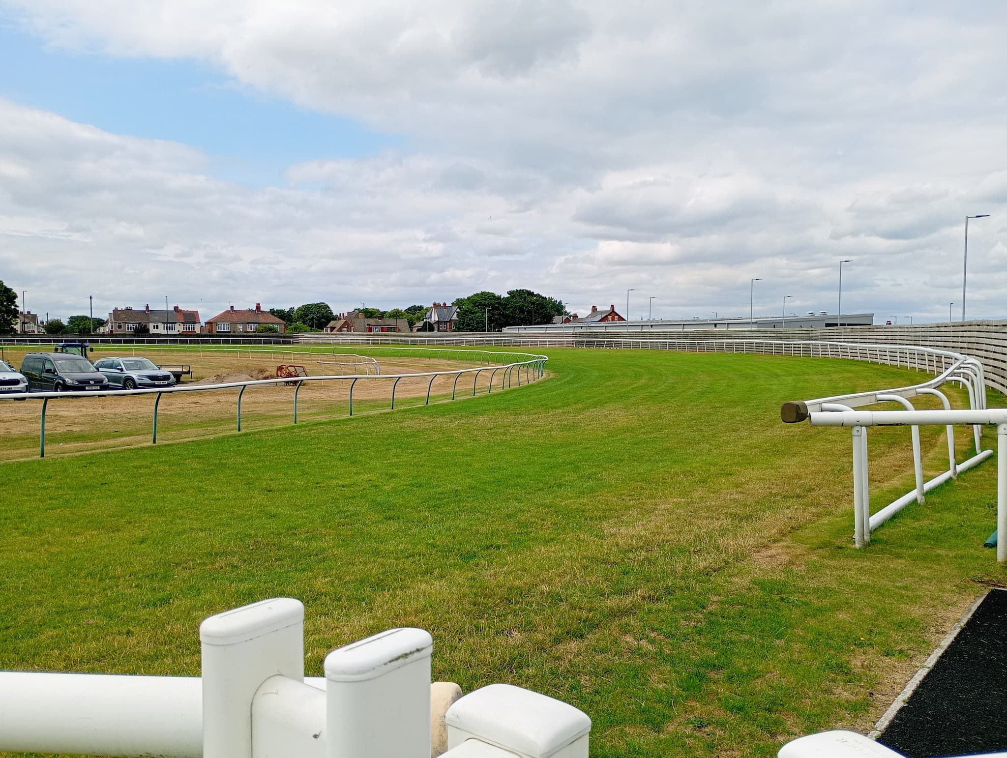 The turn into the back straight at Redcar, the white rail curving away across close-mown turf.