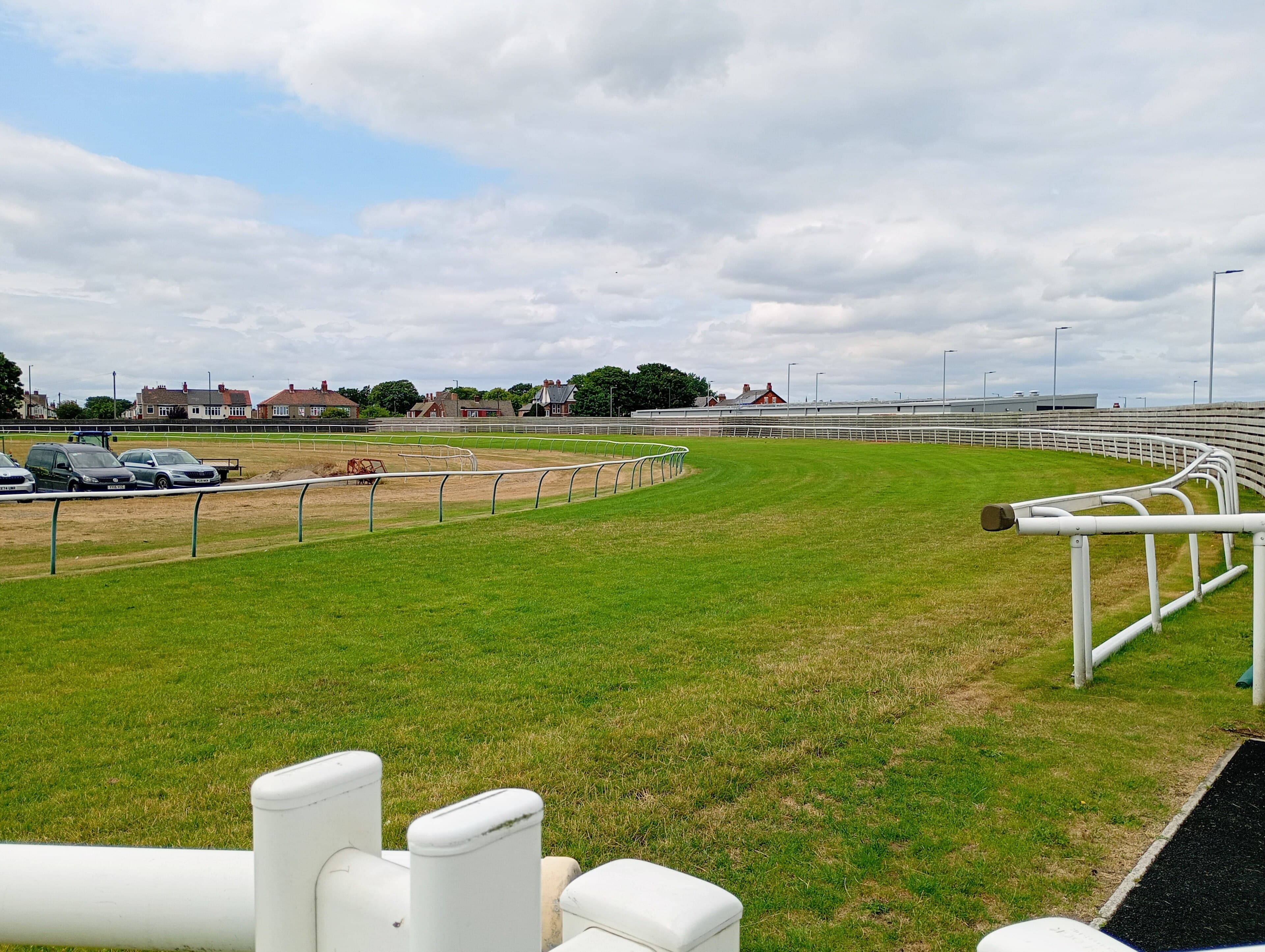 The turn into the back straight at Redcar, the white rail curving away across close-mown turf.