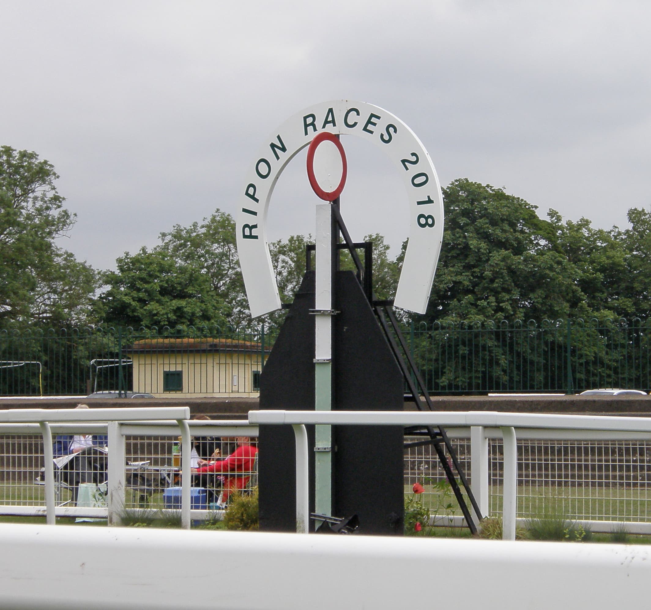 The painted horseshoe arch at Ripon reading Ripon Races, the course behind it.