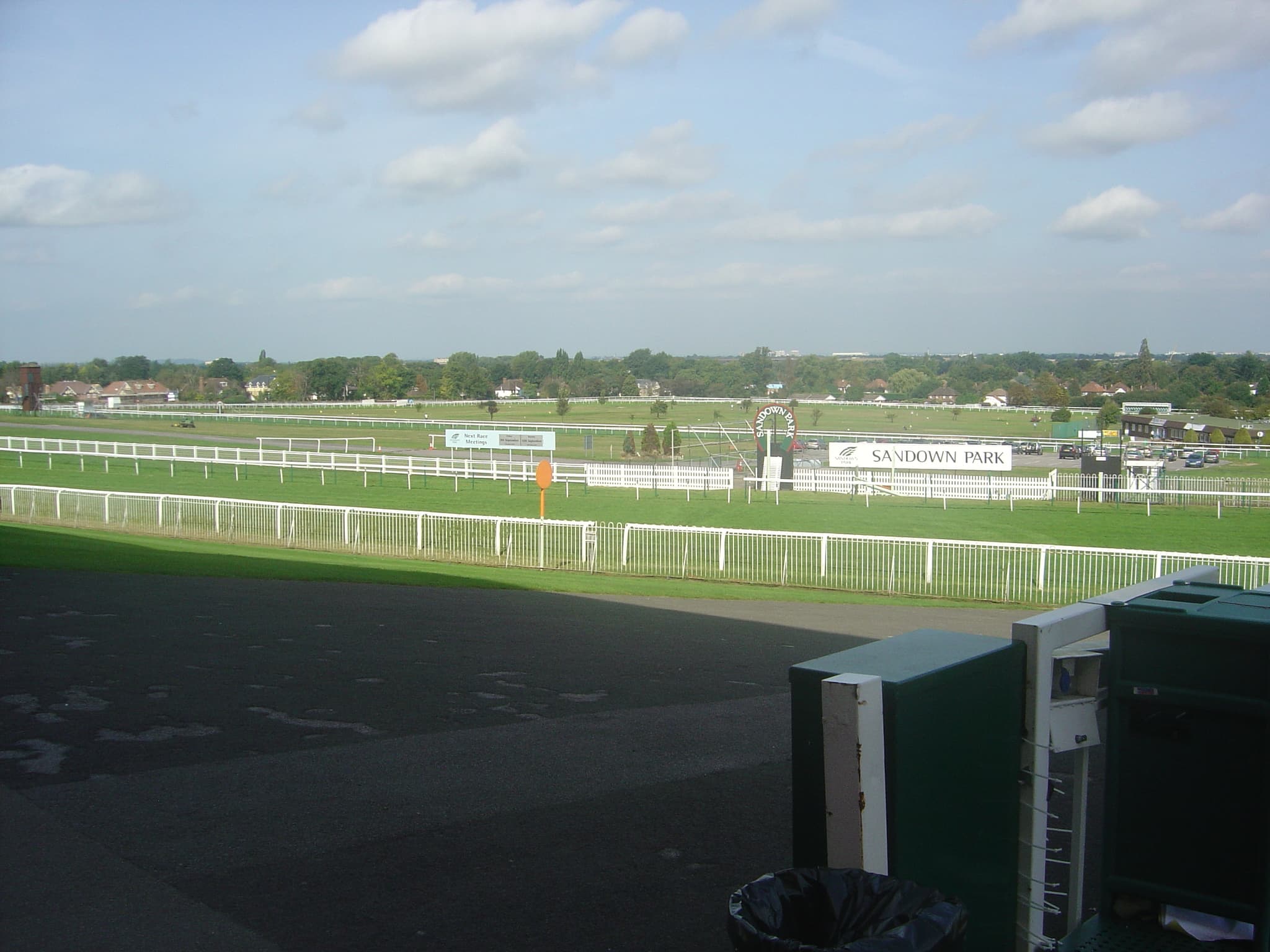 Sandown Park seen from the stand, the Sandown Park boards along the far rail and the course spread out beyond.