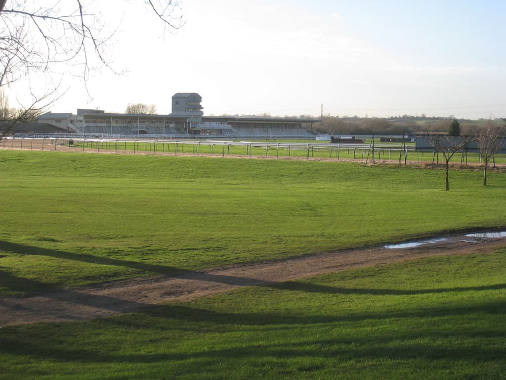 The stands at Southwell Racecourse seen from the fields outside the rail on a clear winter afternoon.