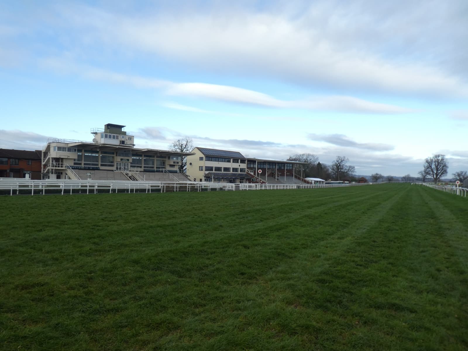 The stands at Taunton across the green turf of the home straight on a bright spring day.