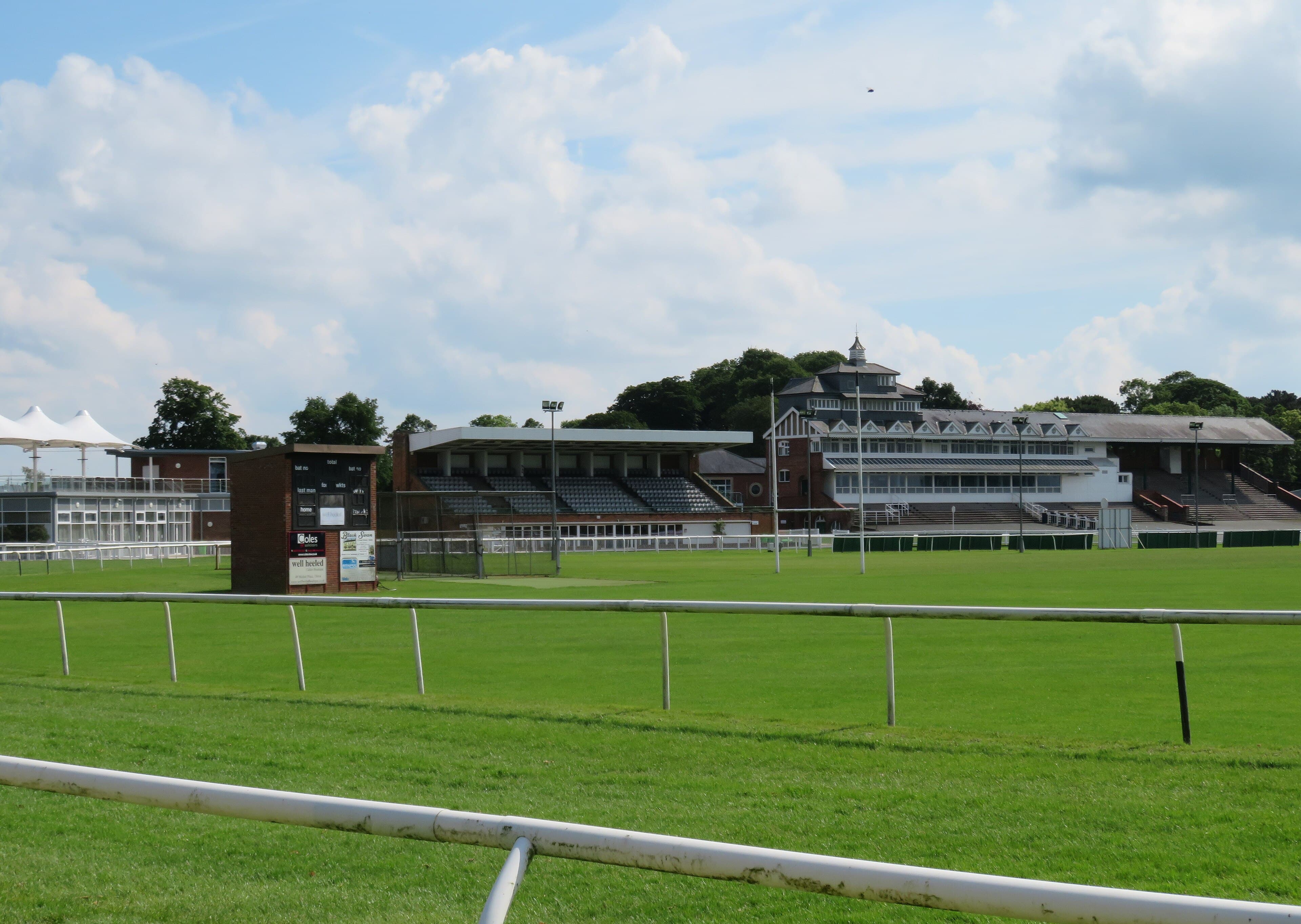The line of stands at Thirsk seen over the running rail on a bright summer afternoon.
