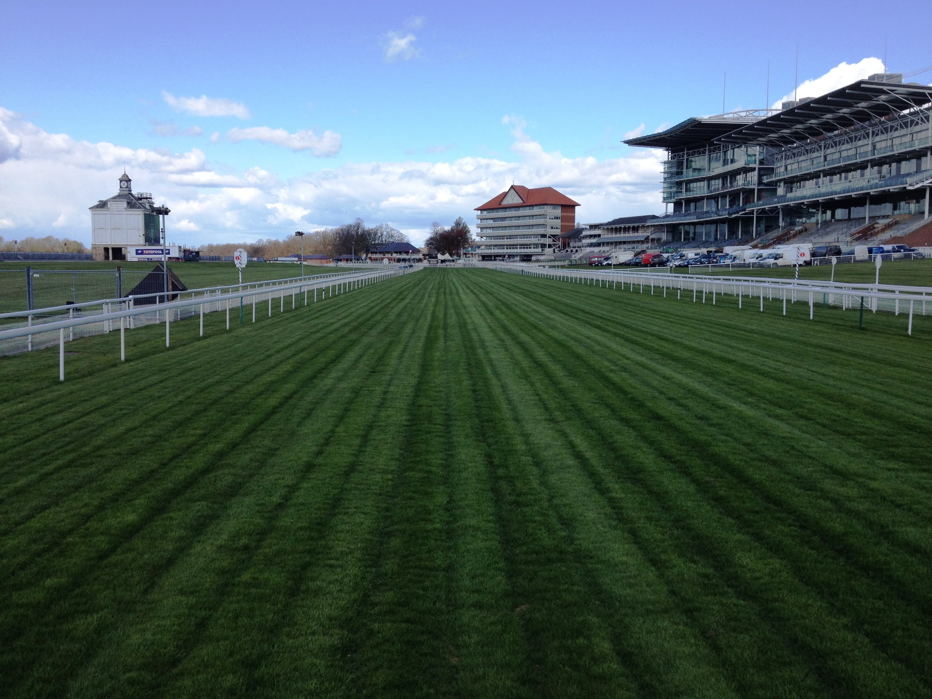 The straight at York looking towards the stands, the turf striped by the mower and the clock tower to the left.