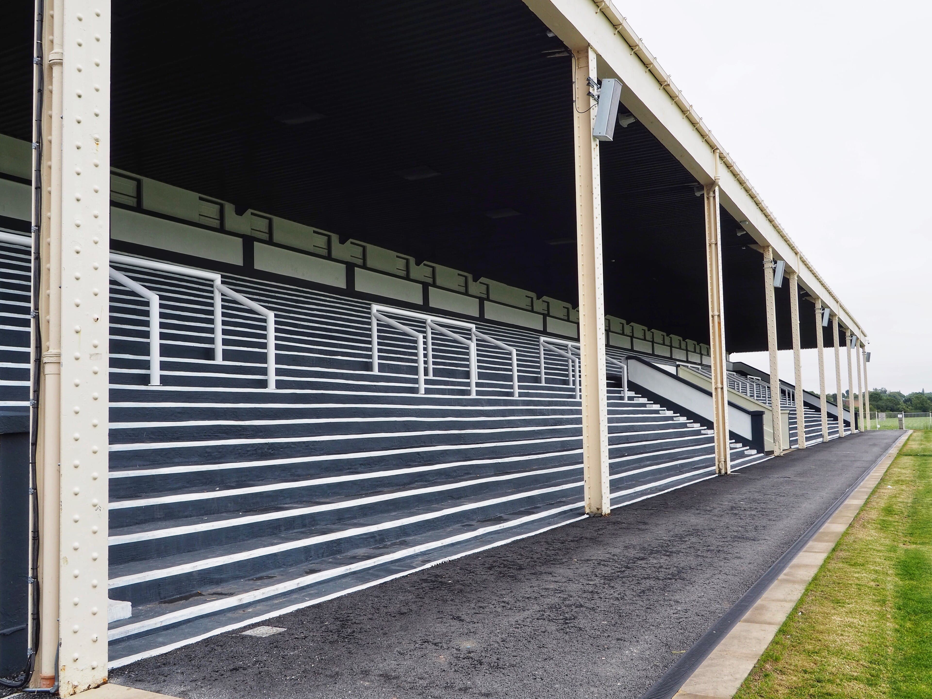 The empty terraces of the Bustardthorpe Stand at York Racecourse under its long canopy.